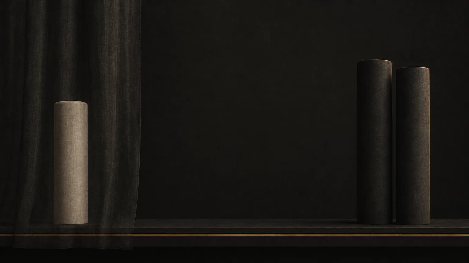 A matte ivory column stands behind a sheer dark veil near the left end of a long low charcoal shelf; two taller dark pillars stand together at the right end, with one brass line along the shelf’s front edge.